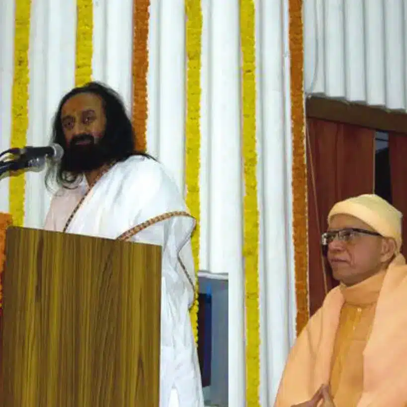 Gurudev stands behind a podium and gives a speech