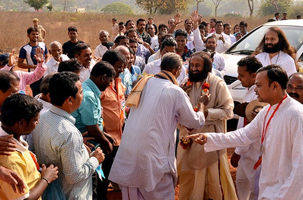 Gurudev being welcomed by the villagers near Sri Sri University
